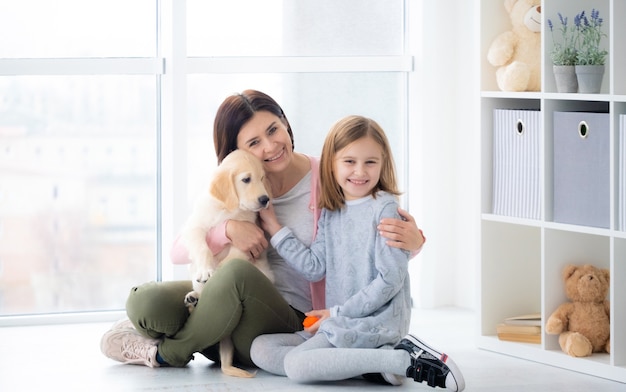 Mère et fille embrassant le chien