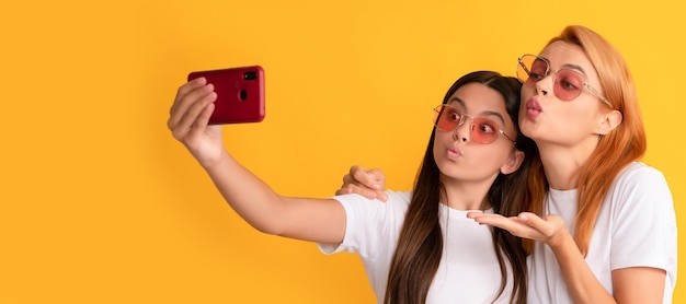 Mère et fille enfant bannière copie espace isolé fond femme heureuse et fille prendre selfie