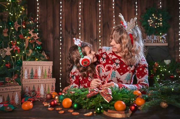 Mère avec fille enfant près de sapin de Noël.