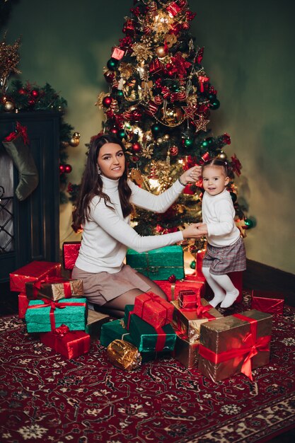 Mère et fille étreignant en tas de cadeaux.