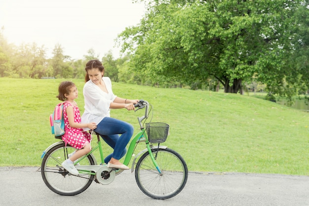 Mère et fille faire du vélo ensemble.