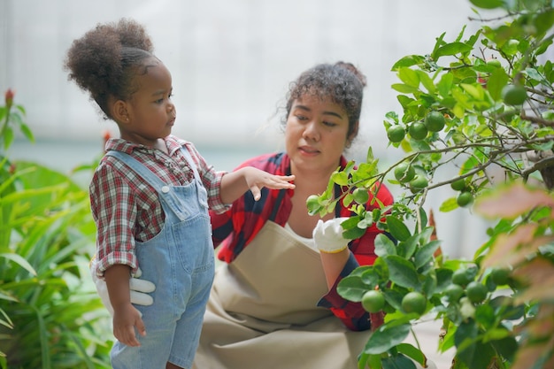 Mère et fille faisant des activités de plein air au jardin famille diversifiée week-end de la maternité heureuse avec enfant concept de la fête des mères