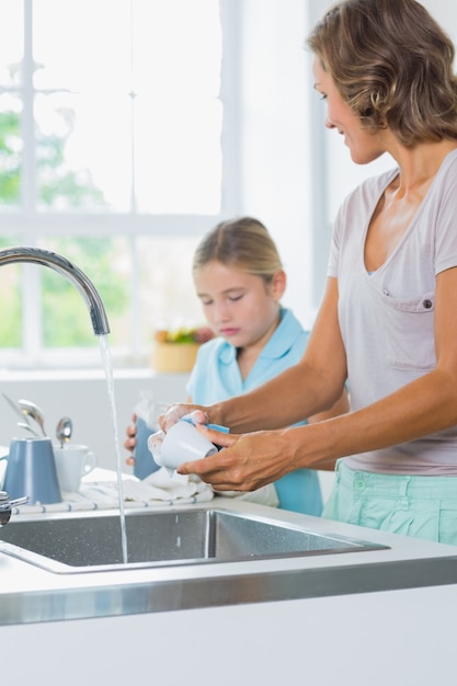 Mère et fille faisant la vaisselle