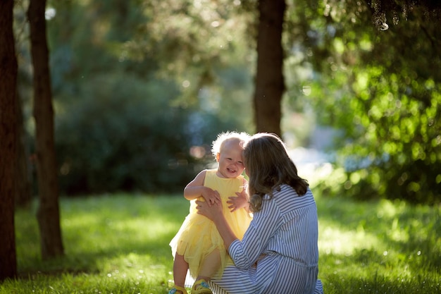 La mère et la fille d'une famille monoparentale se promènent joyeusement dans le parc un jour d'été