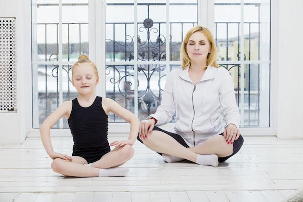 Mère Et Fille Fille Faisant Du Yoga Heureux Et Belles Maisons Sur Un Plancher En Bois Sur La Fenêtre