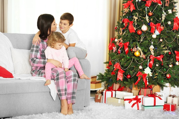 Mère avec fille et fils près de l'arbre de Noël