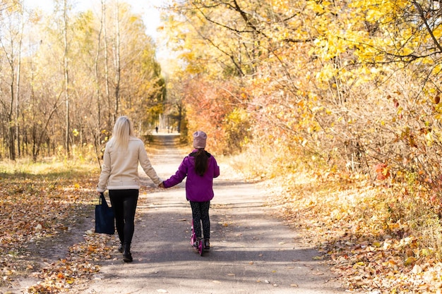 Mère et fille font du scooter dans le parc