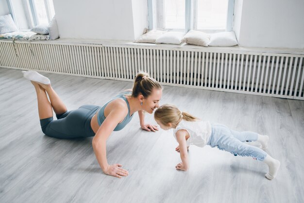 Mère et fille font des exercices ensemble dans la salle de gym