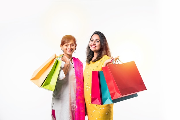 Mère fille indienne sœurs shopping avec des sacs colorés, isolés sur fond blanc