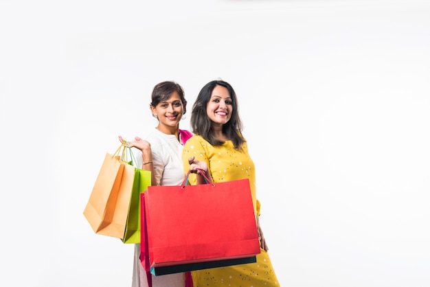 Mère fille indienne sœurs shopping avec des sacs colorés, isolés sur fond blanc