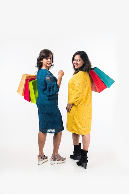 Mère fille indienne sœurs shopping avec des sacs colorés, isolés sur fond blanc