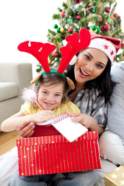 Mère et fille jouant avec des cadeaux de Noël