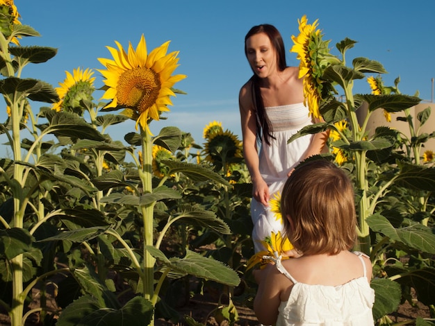 Mère et fille jouant dans le champ de tournesol.