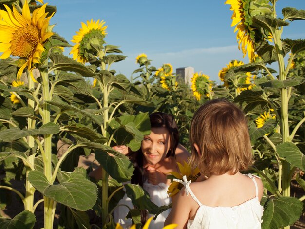 Mère et fille jouant dans le champ de tournesol.