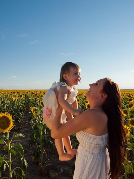 Mère et fille jouant dans le champ de tournesol.