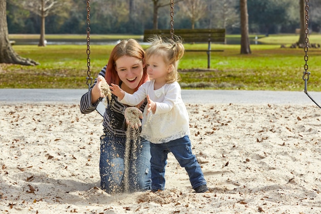Mère et fille jouant avec du sable dans le parc