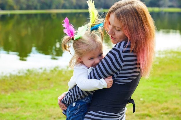 Mère et fille jouant avec des plumes dans le parc