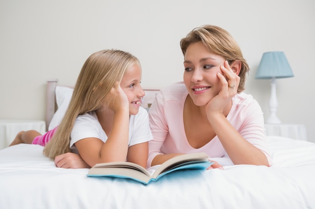 Mère et fille, lecture de livre ensemble sur le lit