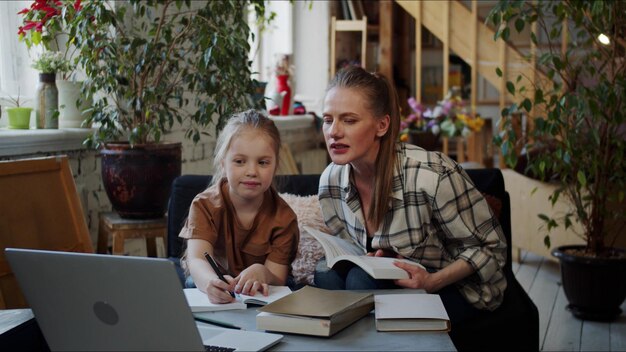 Photo mère et fille lisant un livre à la maison