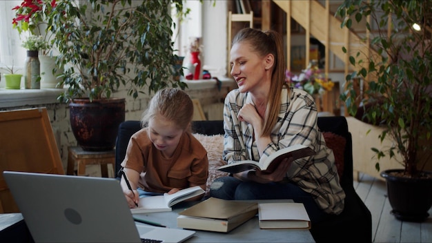 Photo mère et fille lisant un livre à la maison