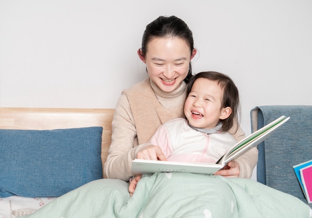 Mère et fille lisent au lit