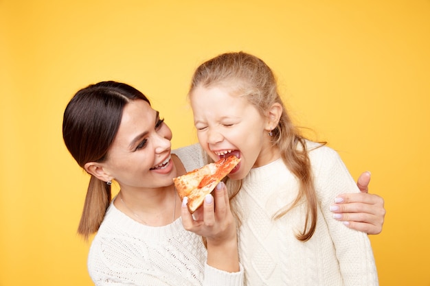 Mère et fille mangeant de la pizza ensemble