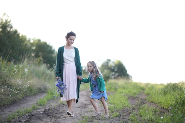 Mère avec fille marchant sur une route