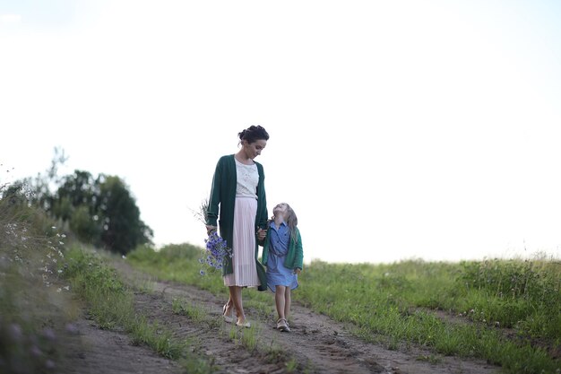 Mère avec fille marchant sur une route