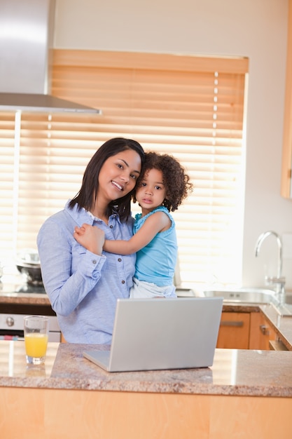 Mère et fille avec ordinateur portable dans la cuisine