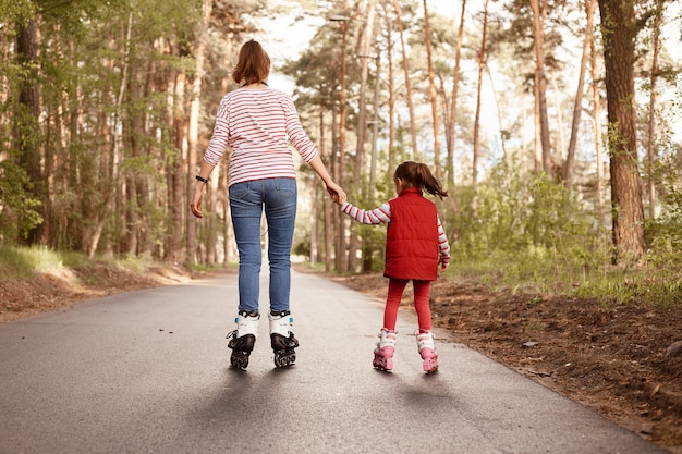 Mère avec fille patin à roulettes dans le parc