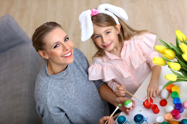 mère et fille peignant des œufs de Pâques à la maison