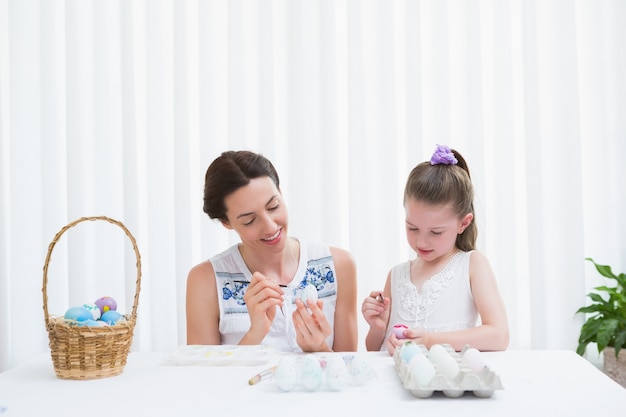 Mère et fille peignant des oeufs de Pâques