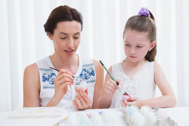 Mère et fille peignant des oeufs de Pâques