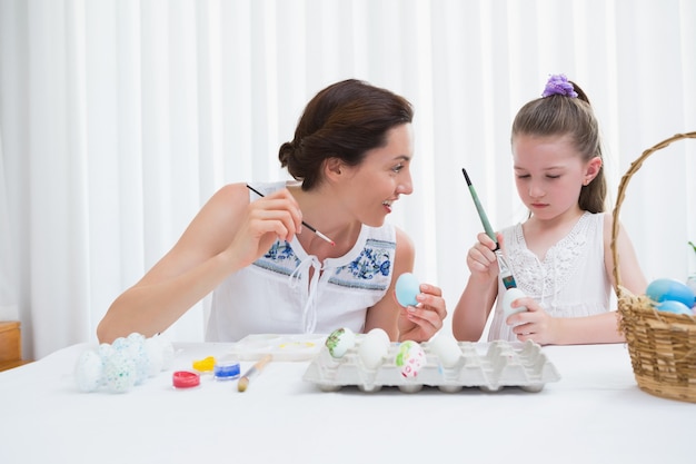 Mère et fille peignant des oeufs de Pâques