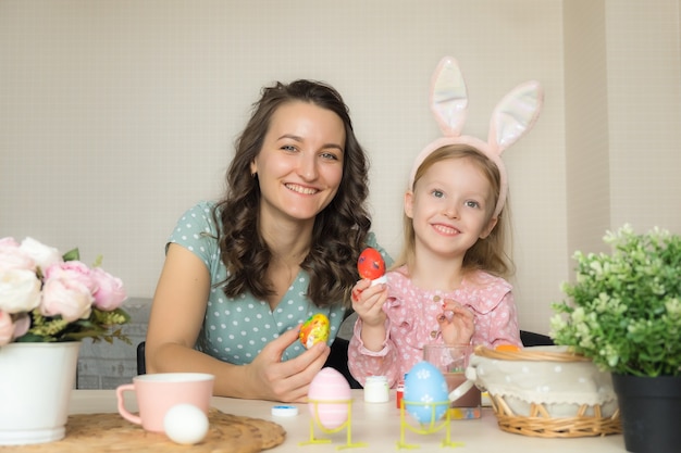 Mère et fille peignant des oeufs pour Pâques