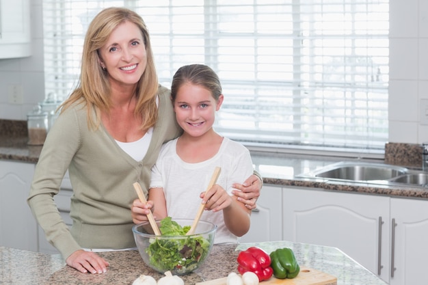 Mère et fille préparant une salade ensemble