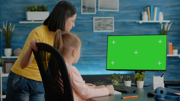 Mère et fille regardant l'écran vert horizontal sur l'ordinateur