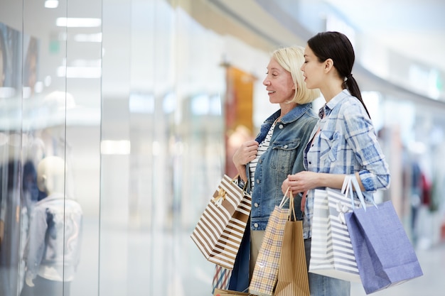 Mère fille, regarder, habillement, par, fenêtre, de, magasin