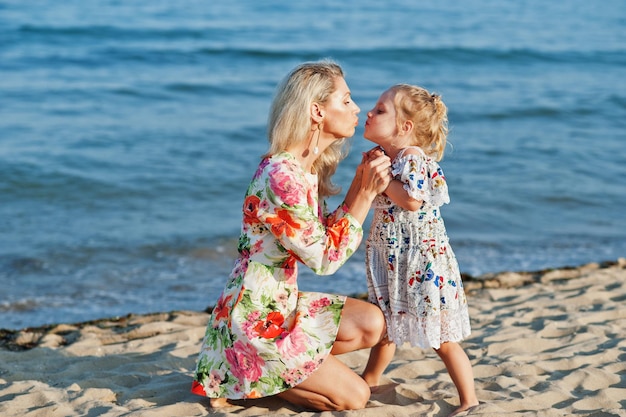 Mère et fille s'amusant sur la plage Portrait de femme heureuse avec jolie petite fille en vacances