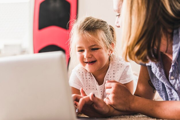 Photo mère et fille s'amusant, utilisant un ordinateur portable