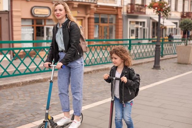 La mère et la fille s'amusent à faire du scooter