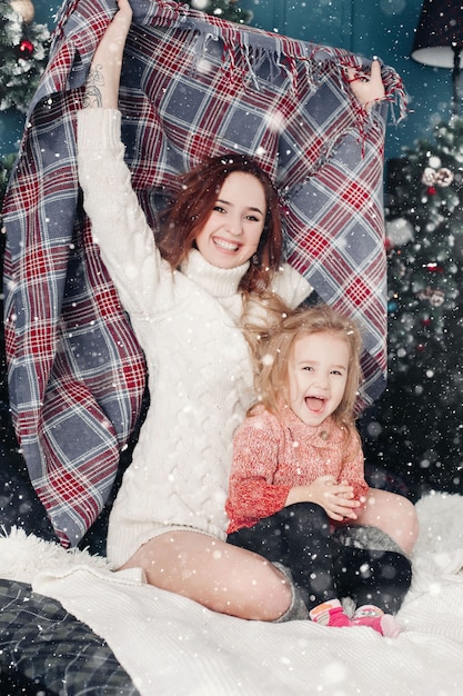 Mère et fille s'amuser avec une couverture