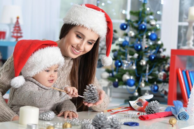 mère et fille se préparant pour Noël à la maison portant des chapeaux de père Noël