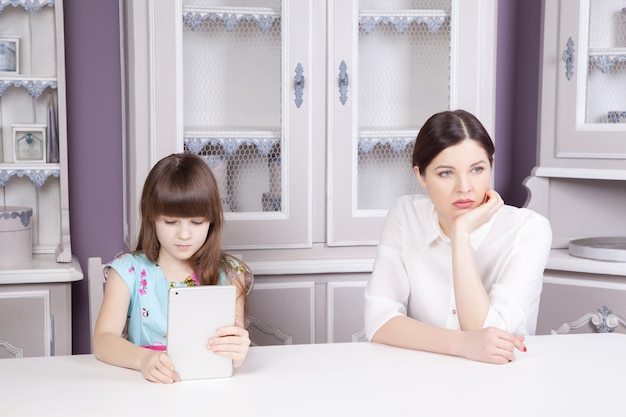 La mère et la fille se querellent à cause de l'abus de la tablette. Problème social entre parents et enfants. Prise de vue en studio..