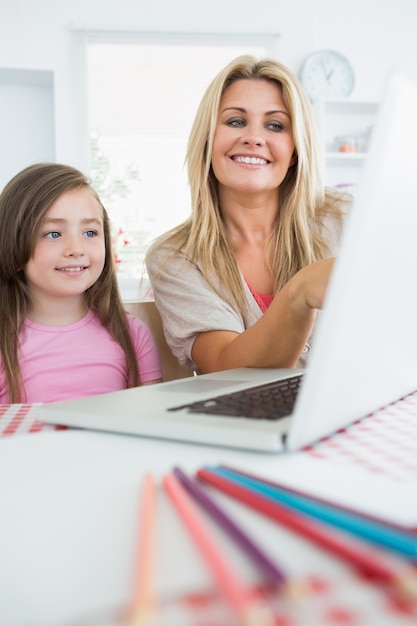 Mère et fille souriant à l&#39;ordinateur portable