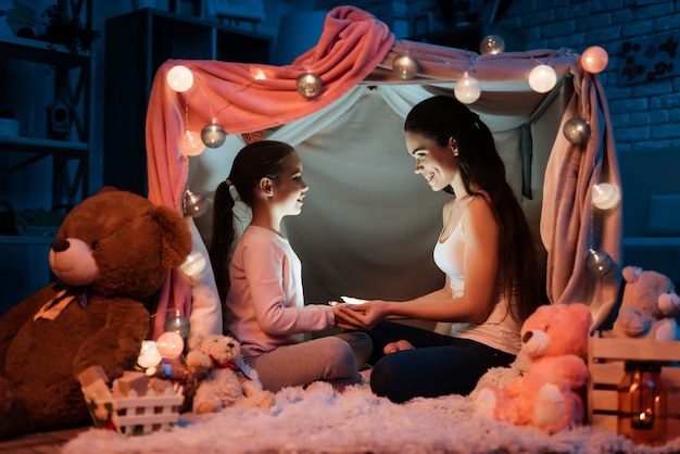 Photo mère et fille tenant la lampe de poche leurs mains.