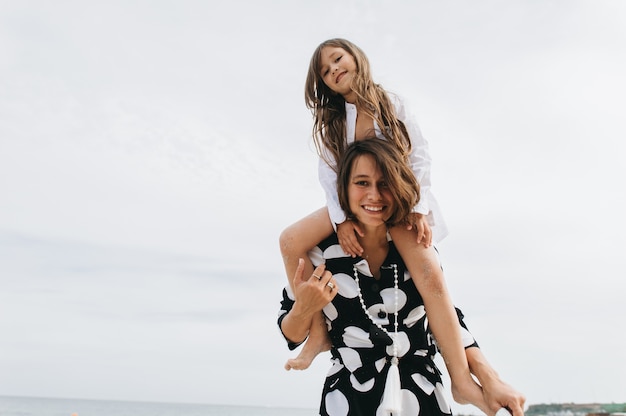 Mère et fille tenant par la main et marchant sur la plage