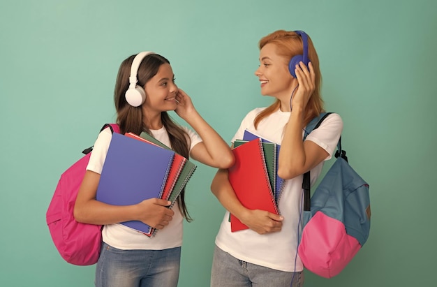 Mère et fille tiennent un cahier pour retourner à l'école l'éducation en ligne de l'enfance