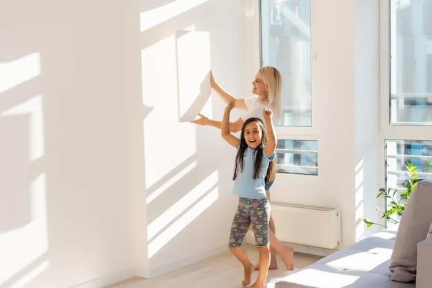 mère et fille tiennent une toile photo à la maison