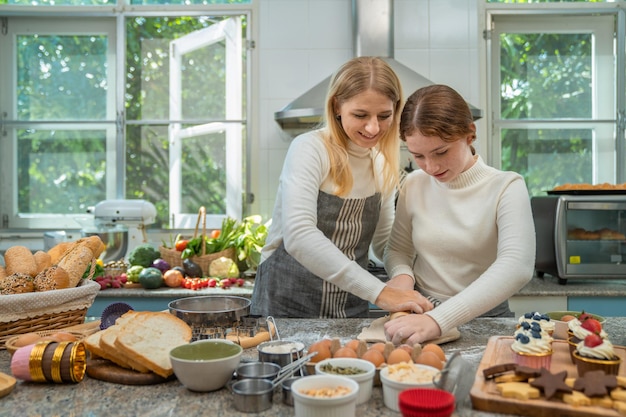 Photo mère et fille travaillant joyeusement ensemble pour faire des bonbons pendant les vacances.